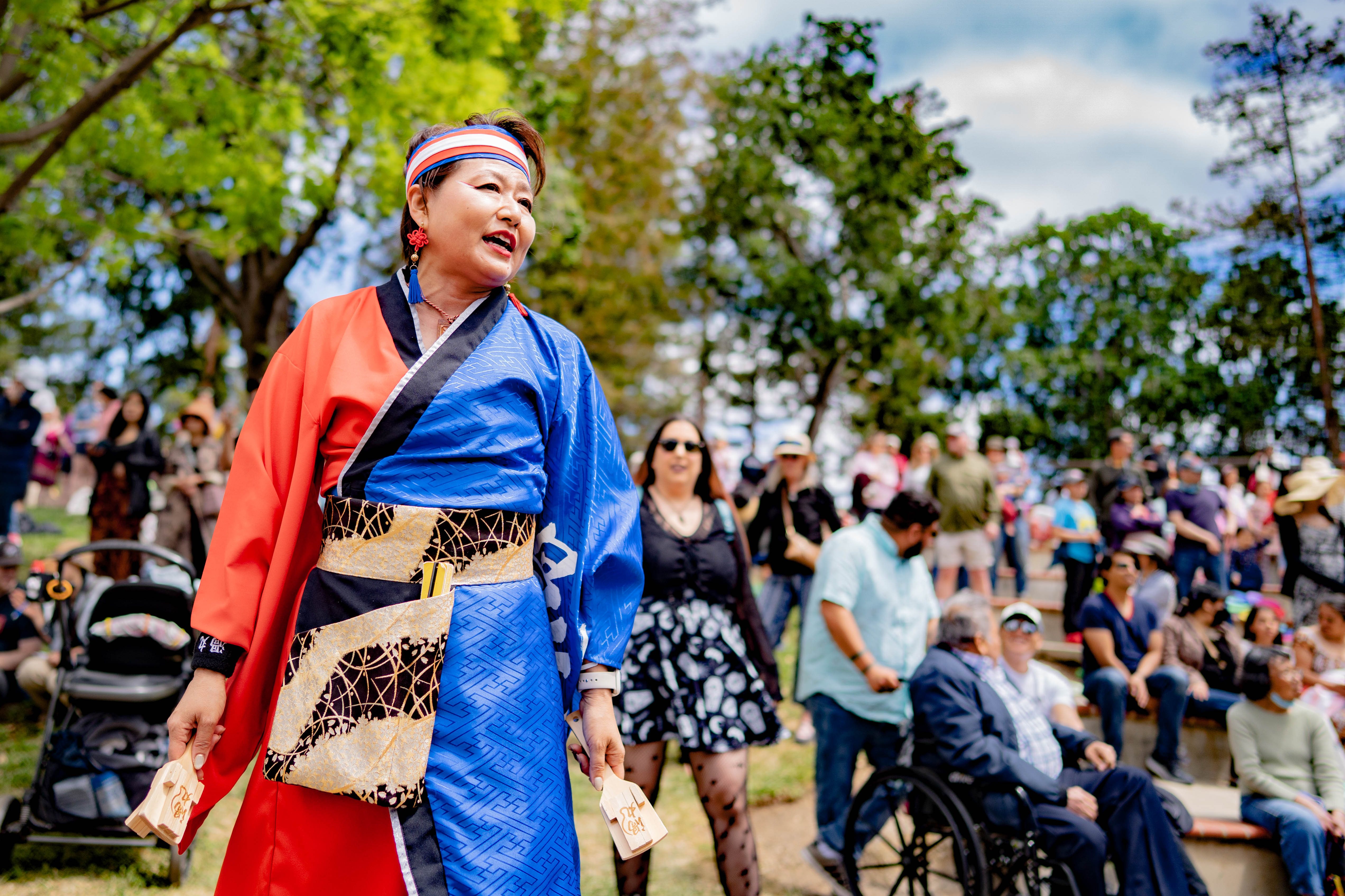 屋外で鳴子を手に踊る渦丸の踊り手と、周囲で観覧する人々